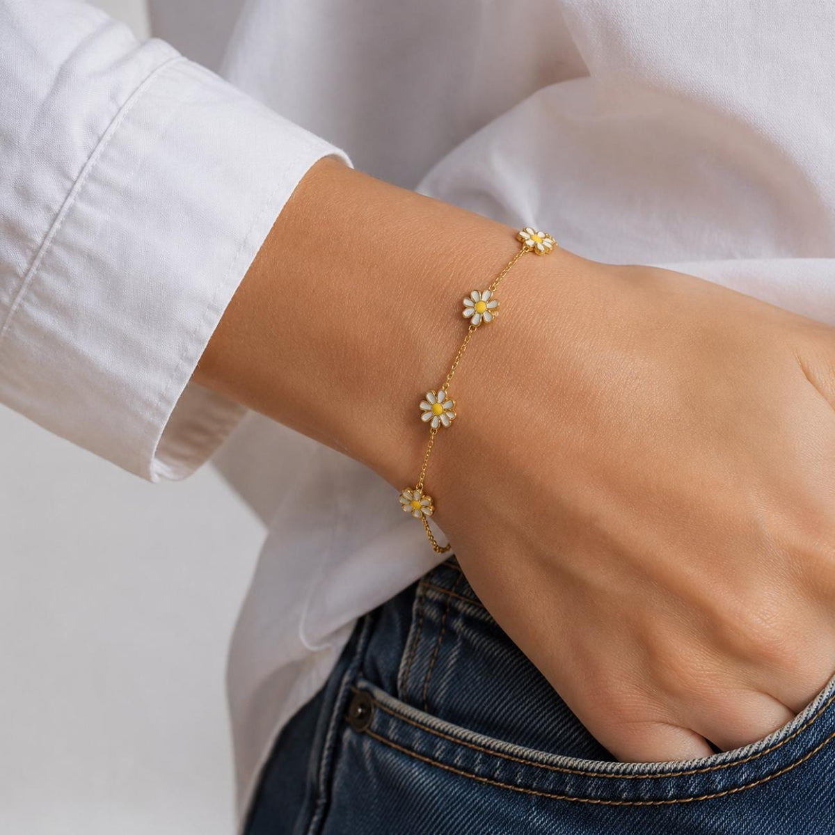 dainty daisy bracelet with enamel white and yellow flowers spaced along a minimalist chain, gold plated water proof summer bracelet