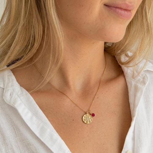 model wearing a guiding star necklace with a birthstone charm